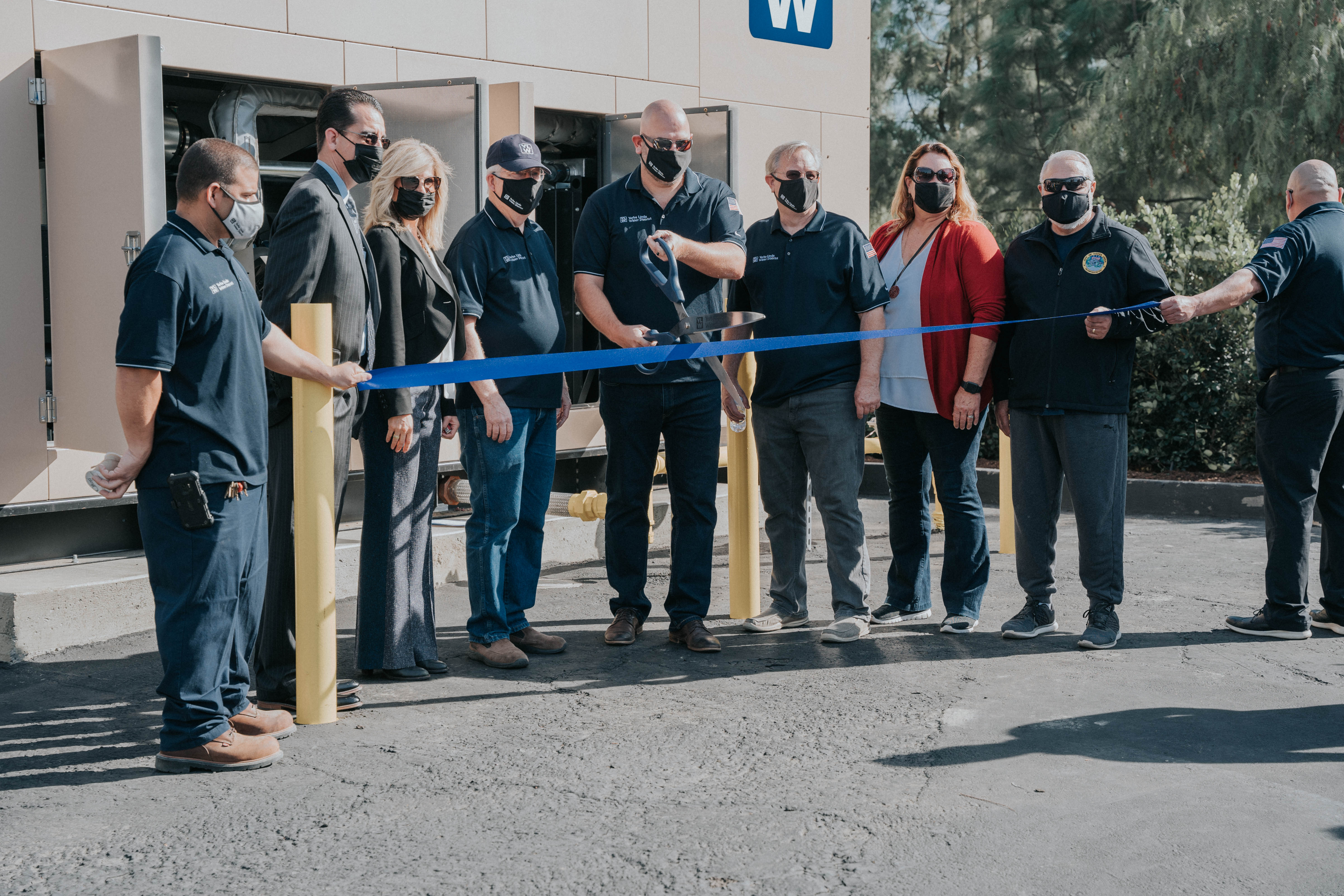 YLWD Board and YL City Council cut a large ribbon in front of the elk mountain natural gas generator