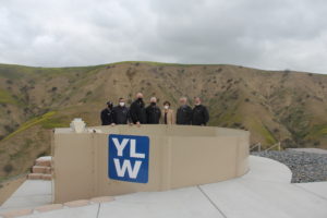 people standing behind a water tank, smiling