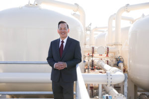 Mark Toy leaning on railing front of 22 ft tall ion exchange vessels