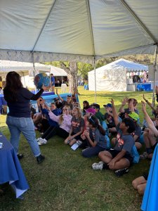 Grade school children raising their hands at the OCWD Water Education Festival