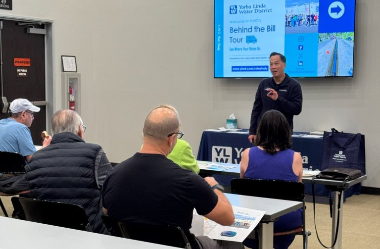 General Manager Mark Tour Presenting with TV screen behind him with powerpoint presentation