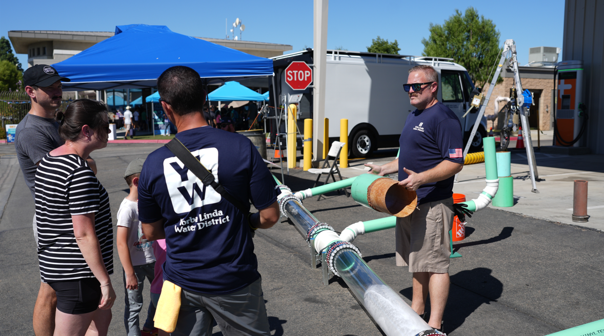 Adults and children gather around a Wastewater Demonstration at an event